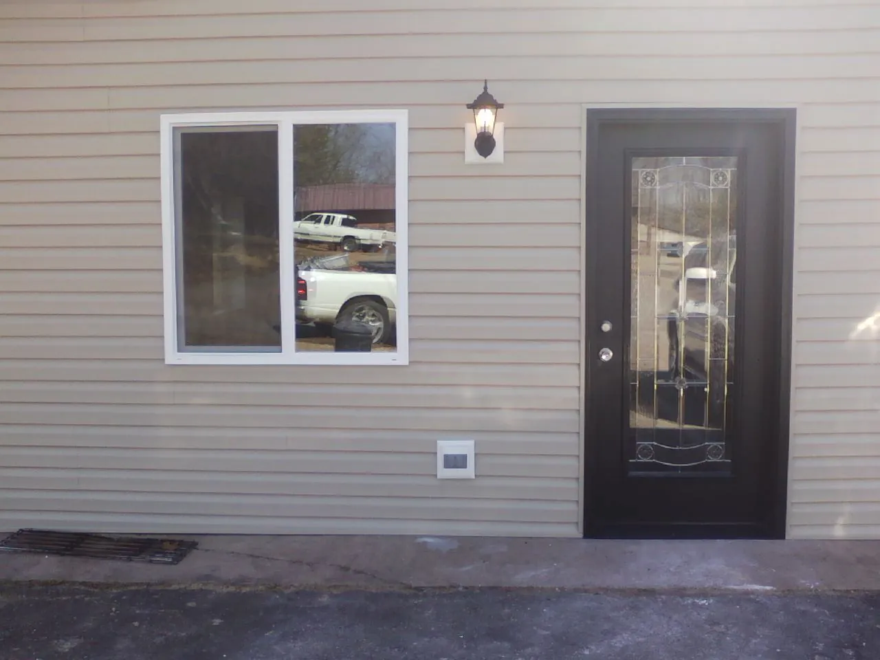 New siding, window and entry door on the side of an addition in Farner