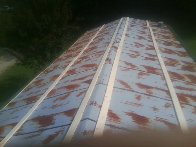 Rusted metal roof panels with new wood purlins before replacement — Storm Damage Roof Repair in Farner by Roofing Brothers