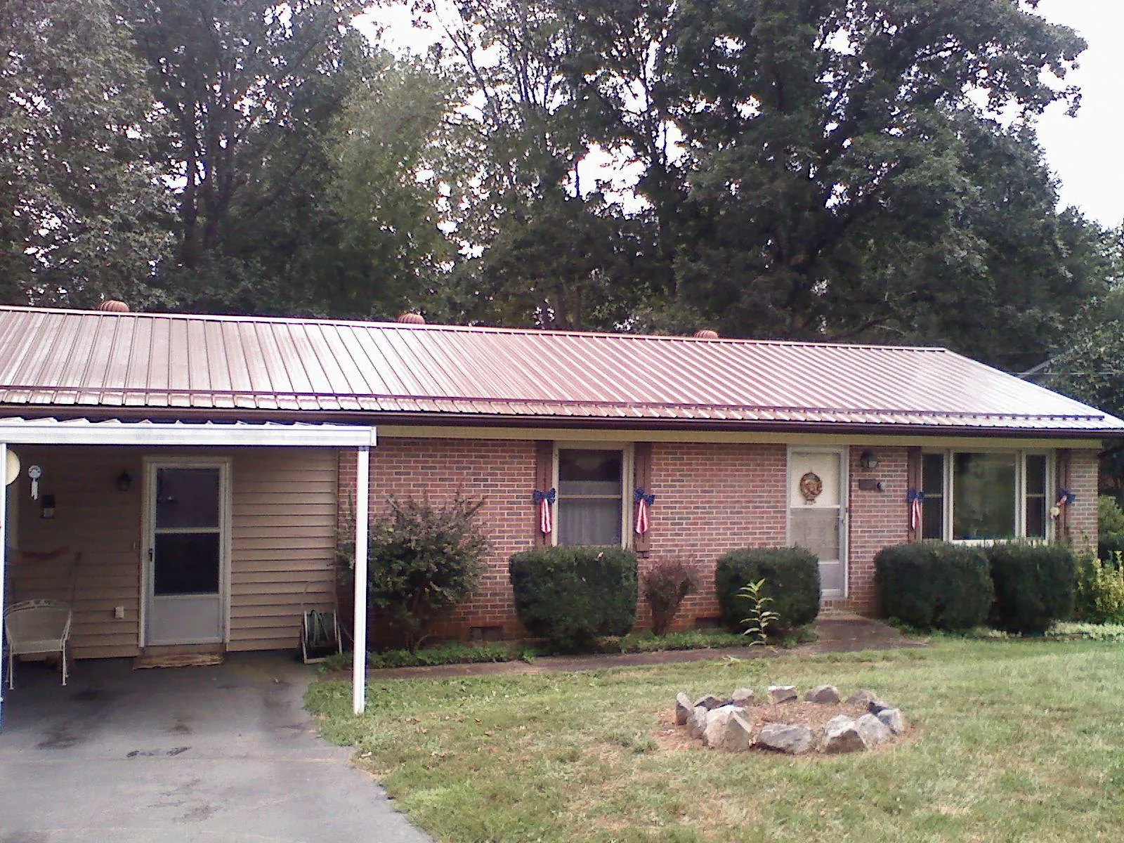 Bronze metal roof and carport on a brick ranch home — Roof Repair work by our crew in Farner